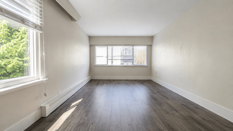 A room with wooden floors and a window letting in natural light.