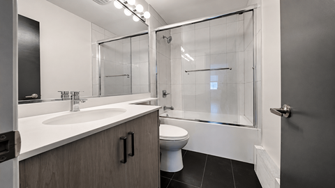 A modern bathroom with a white sink and a walk-in shower.