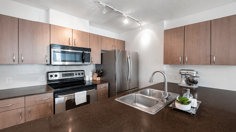 A kitchen with brown cabinets and a stainless steel sink.