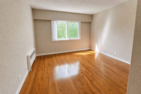A room with a window and wooden floors.