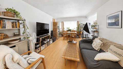 A living room with a grey couch and a wooden coffee table.