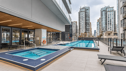 A swimming pool on a rooftop with a cityscape in the background.