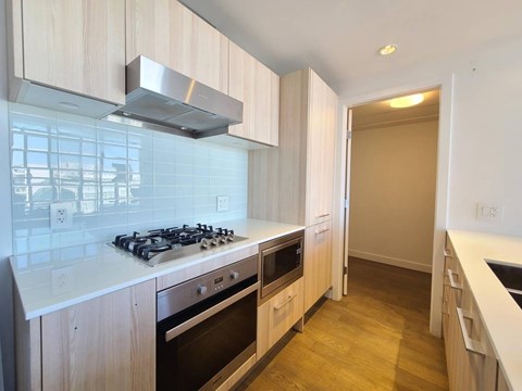 A kitchen with a stove top oven and a range hood.