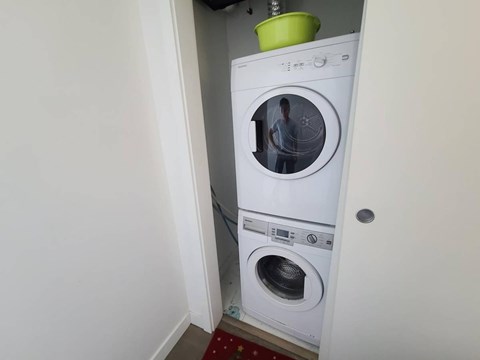 A white washing machine is in a small room.