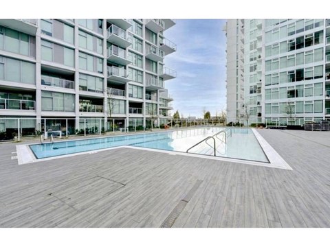 A large wooden deck with a pool in the middle of it.