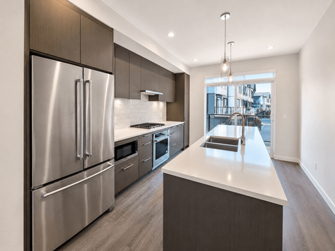 A modern kitchen with stainless steel appliances and a large island.