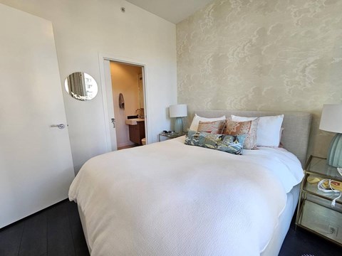 A bedroom with a large bed and a mirror on the wall.