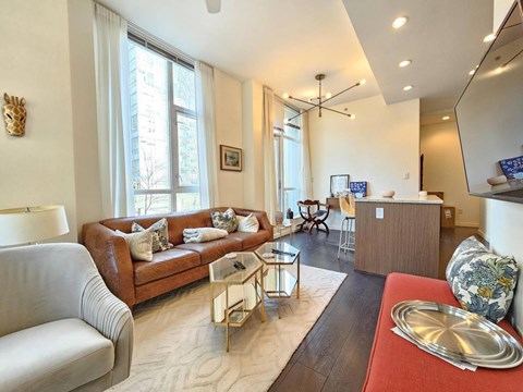 A living room with a brown couch and a coffee table.
