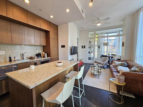 A kitchen with a counter and chairs.