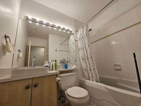 A bathroom with a white toilet, sink, and bathtub.