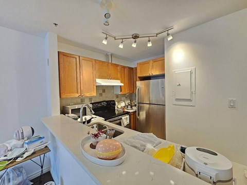 A kitchen with a counter and a fridge.