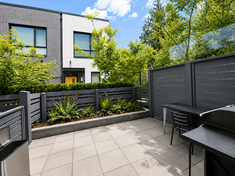 A modern house with a grey exterior and a small garden area.