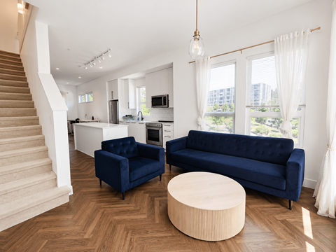 A living room with a blue couch and a wooden coffee table.