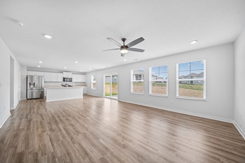 A spacious room with a ceiling fan and wooden flooring.