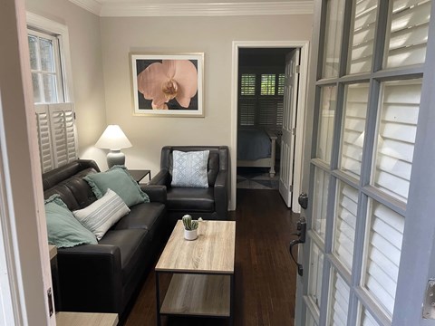 A living room with a couch, a coffee table, and a painting on the wall.