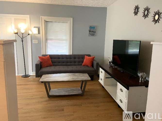 A living room with a grey couch and a wooden coffee table.