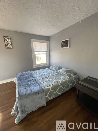 A bedroom with a bed and a window.