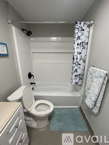 A bathroom with a toilet, a bathtub, and a shower curtain.
