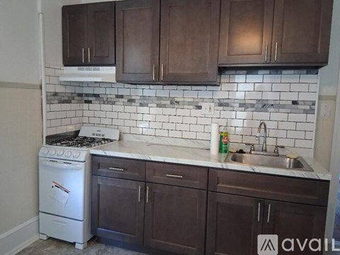 A kitchen with brown cabinets and a white dishwasher.