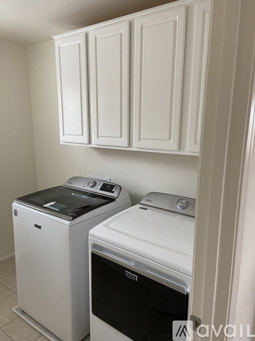 A white washing machine and dryer in a laundry room.