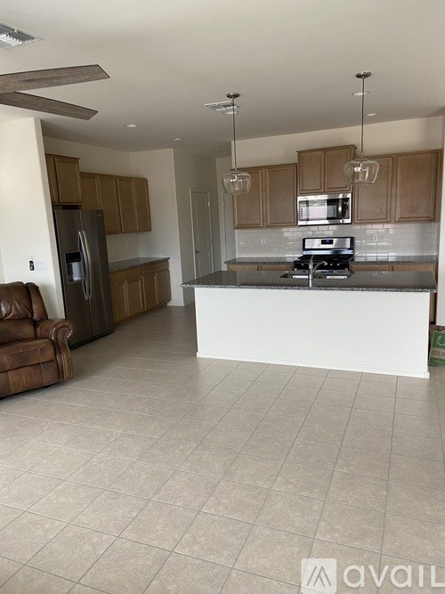 A kitchen with a white island and brown leather chair.