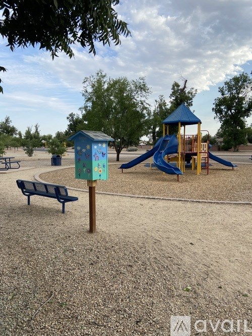 A playground with a blue slide and a blue bench.