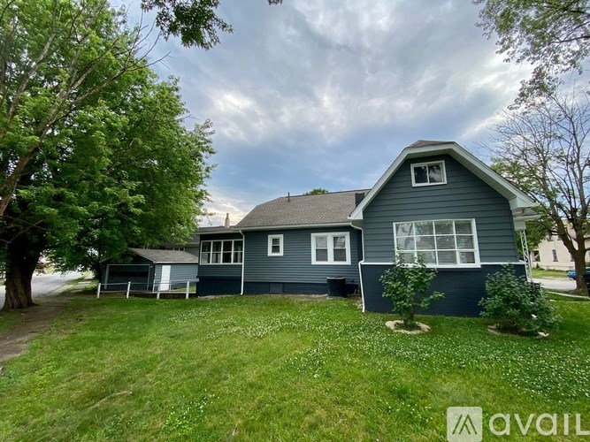 A house with a green lawn and trees around it.