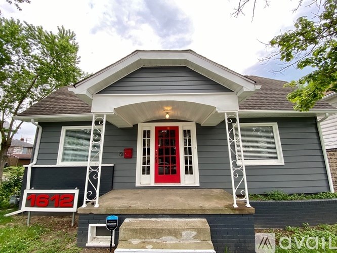 House number 1612 with a red door and a mailbox.