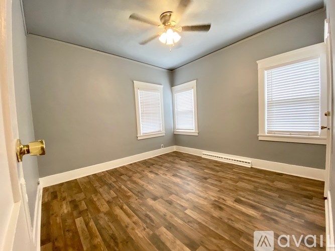 A room with wooden flooring and a ceiling fan.