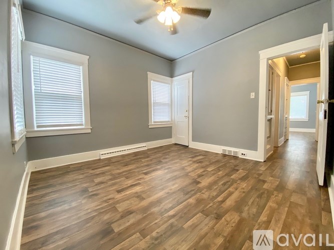 A room with wooden flooring and a ceiling fan.