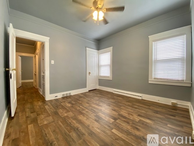 A room with wooden flooring and a ceiling fan.