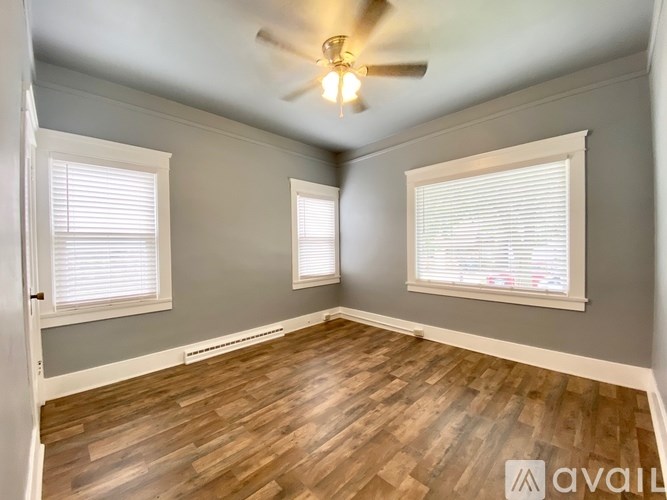 A room with wooden floors and a ceiling fan.