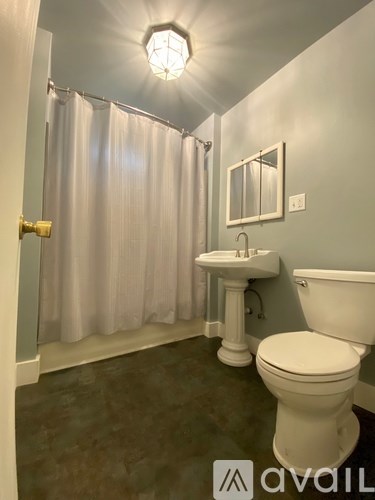 A bathroom with a toilet, sink, and shower.