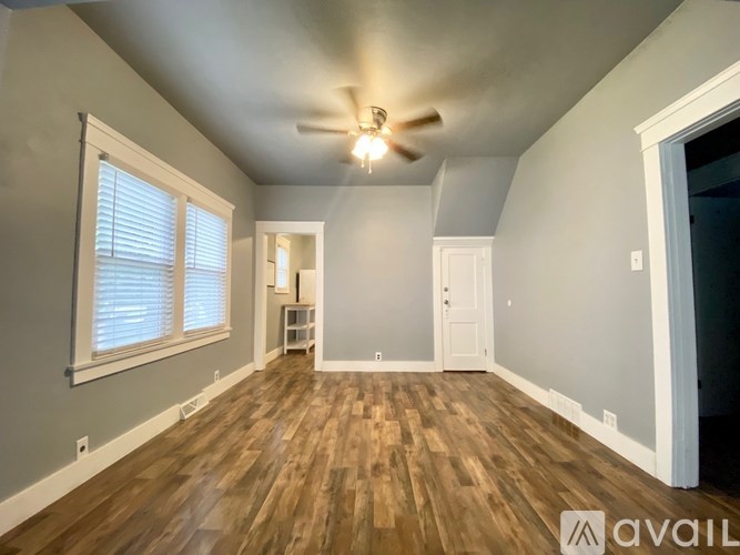 A room with wooden flooring and a ceiling fan.