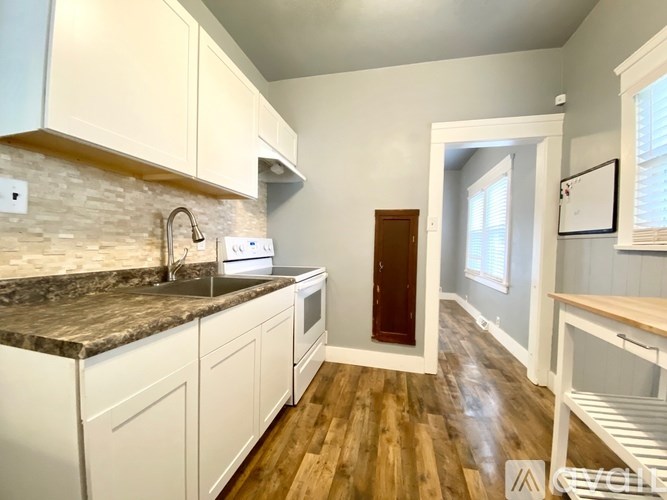 A kitchen with white cabinets and a granite countertop.