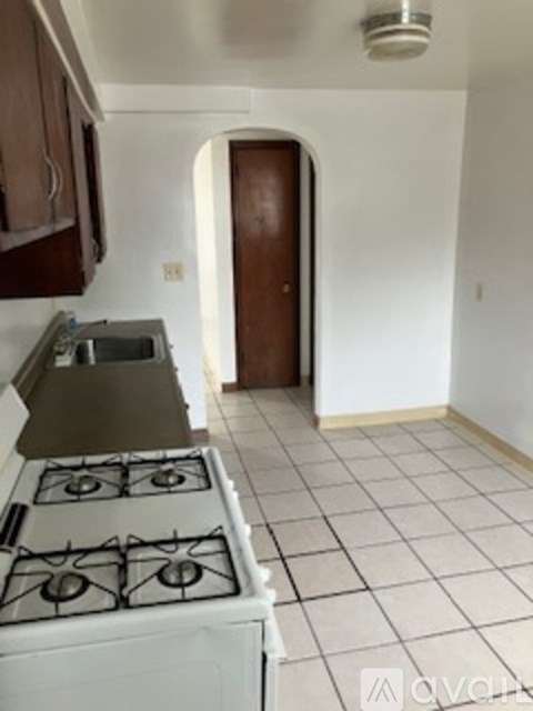 A kitchen with a stove top oven and a sink.