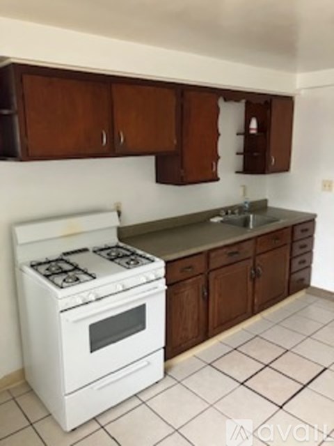 A white stove in a kitchen with brown cabinets.