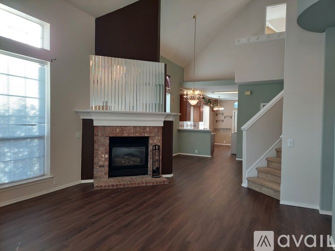 A living room with a fireplace and a staircase.