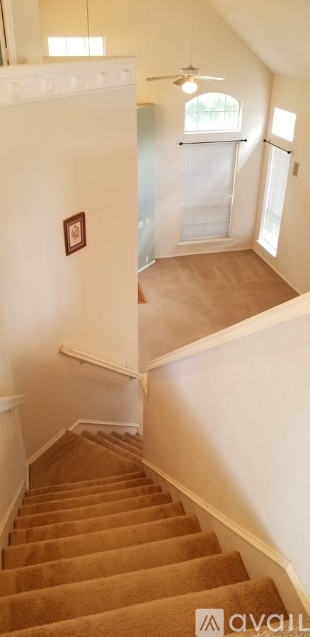 A brown carpeted staircase leads to a second floor.