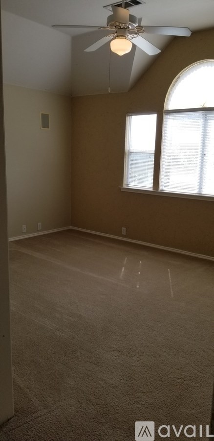 A room with a ceiling fan and a window.