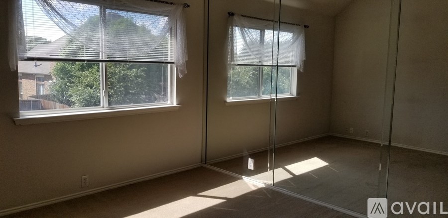 A room with two windows and a glass door.