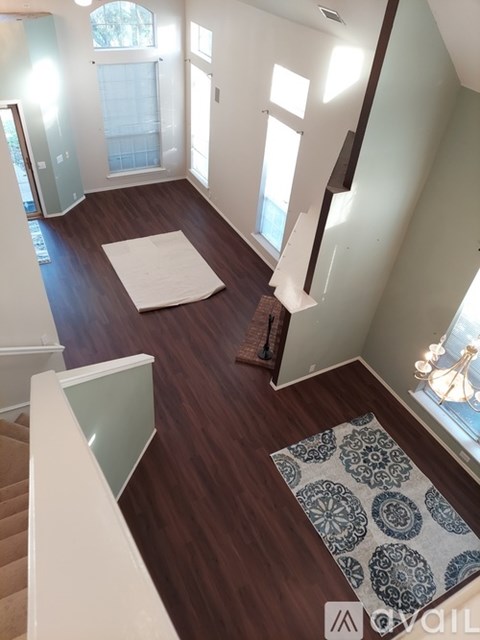A living room with a rug and a staircase.