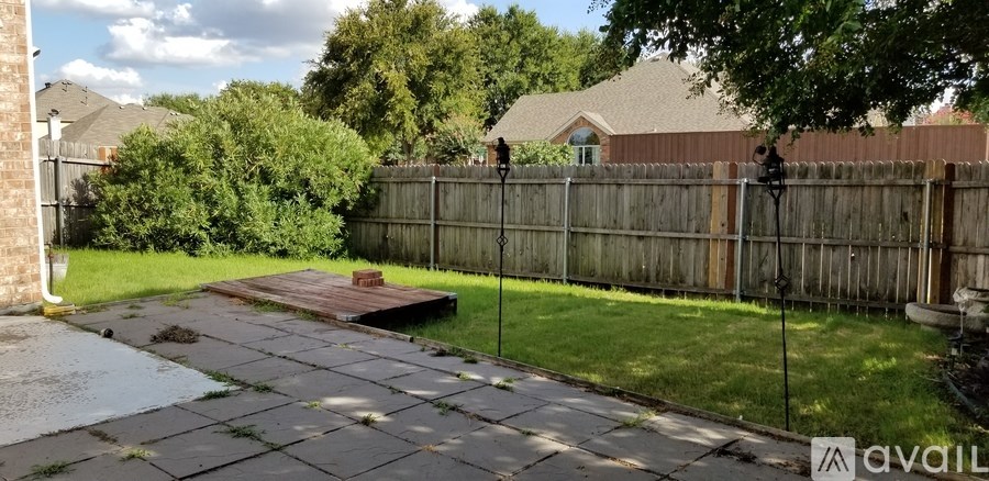 A backyard with a wooden fence and a brick wall.