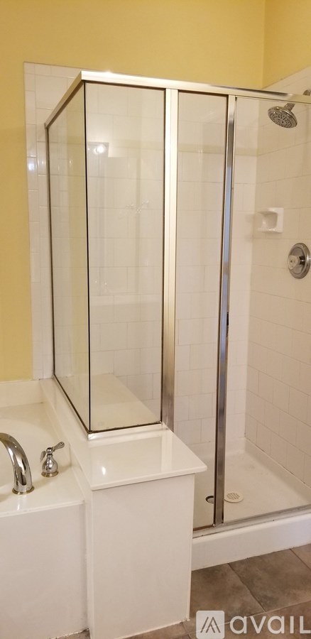 A bathroom with a white sink and a glass shower door.