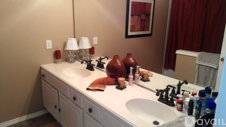 A bathroom with a white counter top and a white sink.