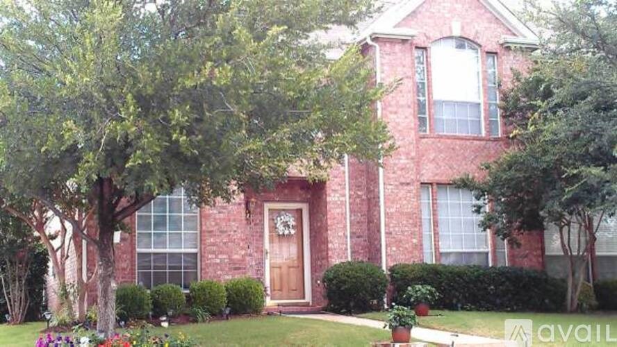 A red brick house with a brown door and windows.