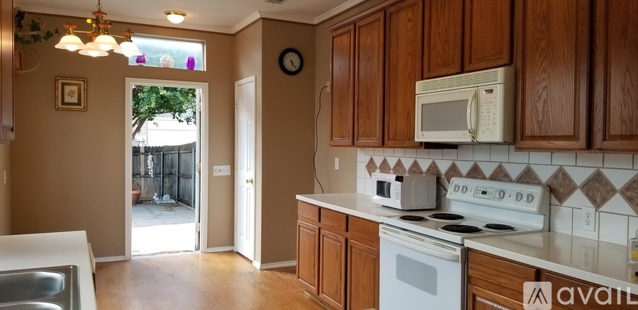 A kitchen with wooden cabinets and a white stove top oven.
