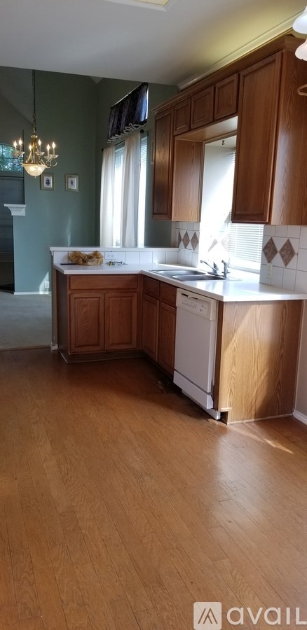 A kitchen with wooden cabinets and a white dishwasher.