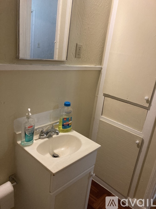 A bathroom with a white sink and a white door.