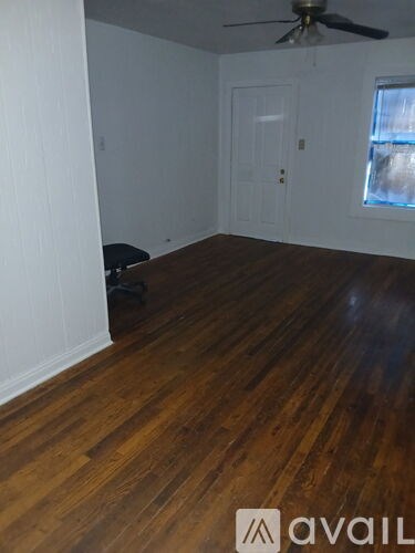 A room with wooden floors and a ceiling fan.